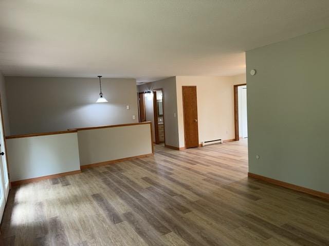 240 12th Ave, Grand Rapids, MN 55744 - spare room with light wood finished floors and a baseboard heating unit