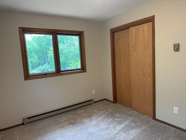 240 12th Ave, Grand Rapids, MN 55744 - unfurnished bedroom with baseboard heating, carpet floors, and a closet