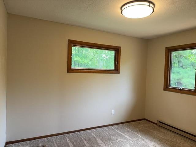 240 12th Ave, Grand Rapids, MN 55744 - empty room featuring a baseboard heating unit and carpet