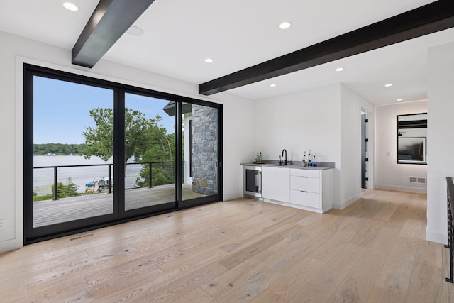 1300 Wildhurst Trl, Orono, MN 55364 - indoor wet bar featuring beamed ceiling, plenty of natural light, wine cooler, light wood-style flooring, and recessed lighting