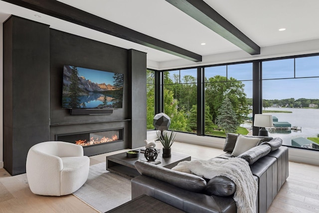 1300 Wildhurst Trl, Orono, MN 55364 - living area featuring light wood-style floors, beamed ceiling, a glass covered fireplace, and recessed lighting