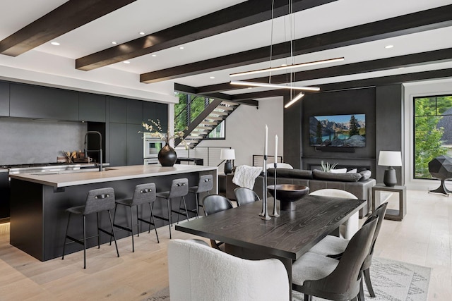 1300 Wildhurst Trl, Orono, MN 55364 - dining space featuring beam ceiling, light wood finished floors, stairs, recessed lighting, and a chandelier