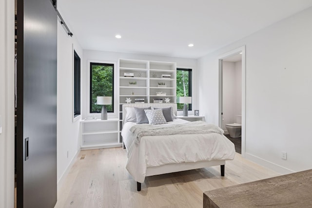 1300 Wildhurst Trl, Orono, MN 55364 - bedroom with light wood-style flooring, a barn door, and recessed lighting