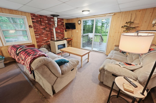 14364 Hummingbird Trl, Bay Lake Twp, MN 56444 - carpeted living room with a wood stove, wooden walls, and a drop ceiling