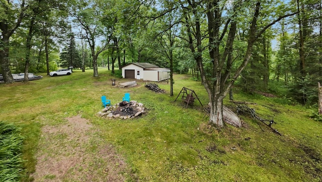 14364 Hummingbird Trl, Bay Lake Twp, MN 56444 - view of grassy yard with an outbuilding, a garage, and a fire pit