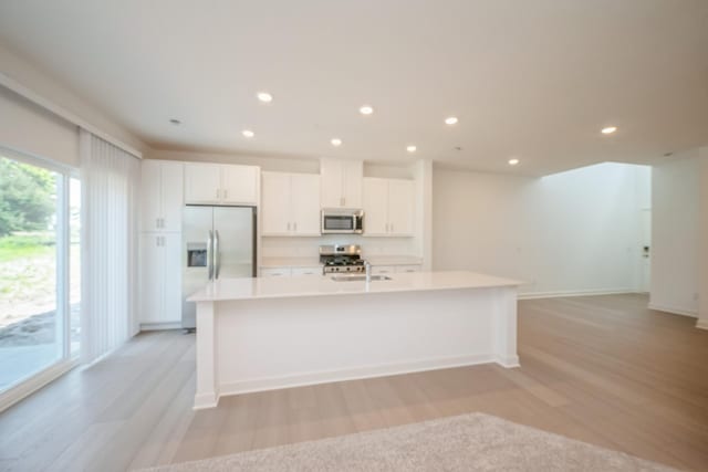 6266 205th St N, Forest Lake, MN 55025 - kitchen featuring stainless steel appliances, light wood-type flooring, an island with sink, white cabinets, and recessed lighting
