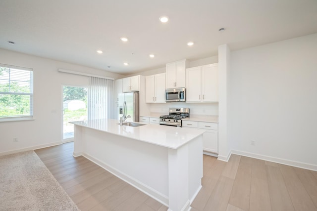 6266 205th St N, Forest Lake, MN 55025 - kitchen with appliances with stainless steel finishes, a kitchen island with sink, white cabinets, light wood-style floors, and recessed lighting