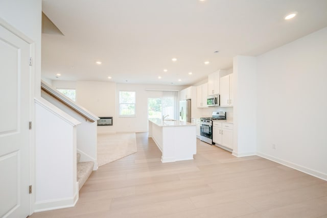 6266 205th St N, Forest Lake, MN 55025 - kitchen featuring stainless steel appliances, open floor plan, an island with sink, white cabinetry, and recessed lighting