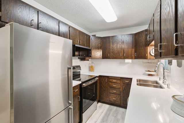 1200 Nicollet Mall Unit 409, Minneapolis, MN 55403 - kitchen featuring appliances with stainless steel finishes, a textured ceiling, dark brown cabinetry, light countertops, and light wood-style floors