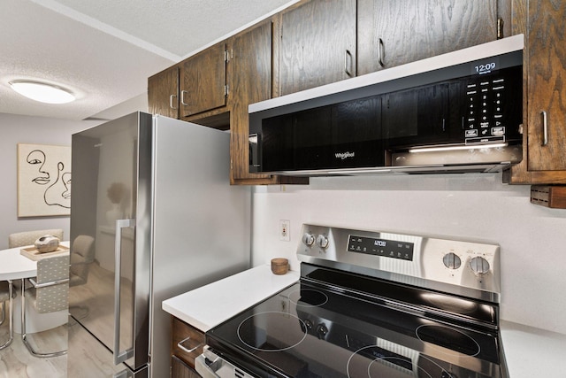 1200 Nicollet Mall Unit 409, Minneapolis, MN 55403 - kitchen with stainless steel appliances, a textured ceiling, light countertops, and dark brown cabinetry