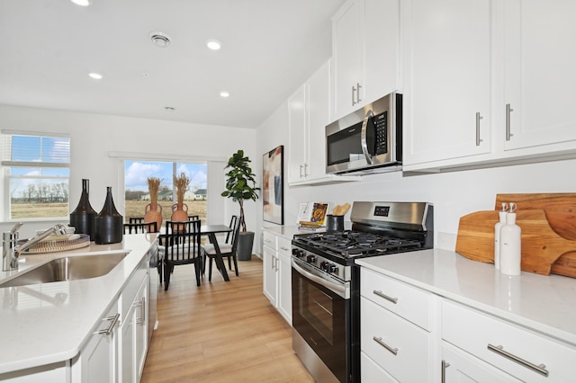 14388 Allerton Way, Rosemount, MN 55068 - kitchen with stainless steel appliances, recessed lighting, white cabinetry, light wood finished floors, and light stone counters