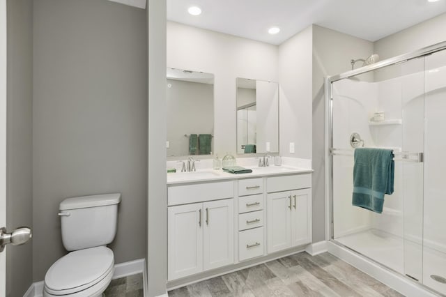14388 Allerton Way, Rosemount, MN 55068 - bathroom featuring a stall shower, double vanity, wood finished floors, and recessed lighting