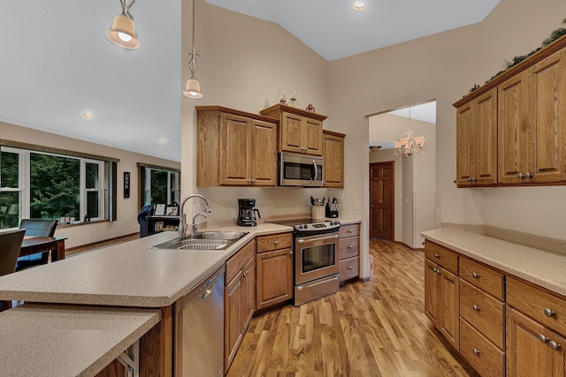 662 Cottonwood Ave, Litchfield, MN 55355 - kitchen featuring appliances with stainless steel finishes, light wood-type flooring, brown cabinetry, a peninsula, and light countertops