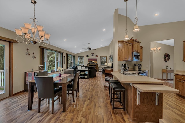 662 Cottonwood Ave, Litchfield, MN 55355 - dining room featuring a chandelier, vaulted ceiling, light wood-type flooring, ceiling fan, and recessed lighting