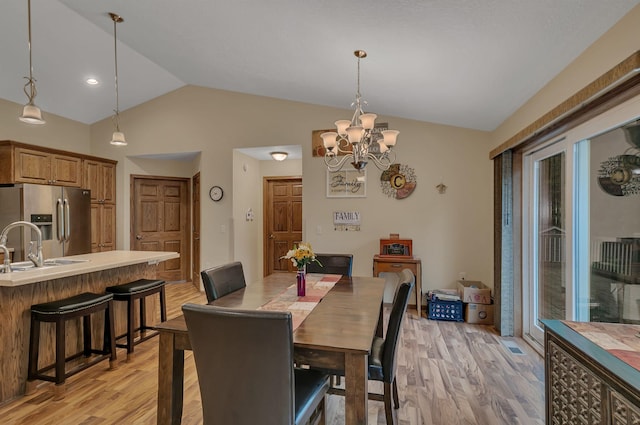 662 Cottonwood Ave, Litchfield, MN 55355 - dining area with light wood-style flooring, vaulted ceiling, a chandelier, and plenty of natural light