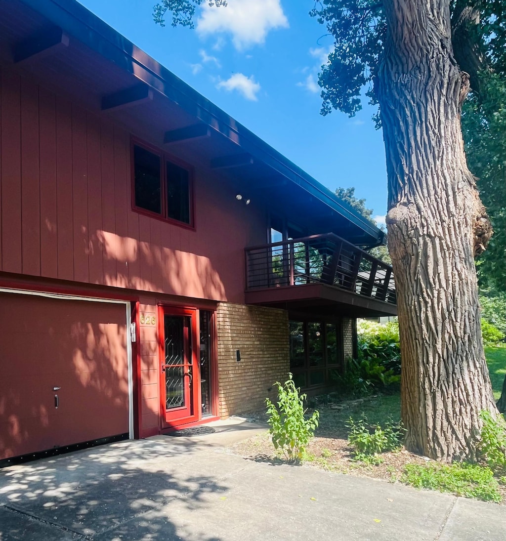 626 Desnoyer Ave, Saint Paul, MN 55104 - view of front of home featuring brick siding, driveway, a balcony, and a garage