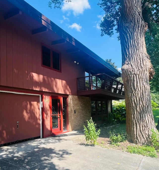 626 Desnoyer Ave, Saint Paul, MN 55104 - view of front of home featuring brick siding, driveway, a balcony, and a garage