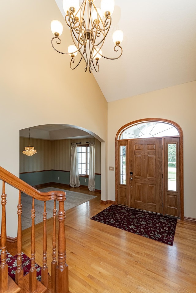 1608 Greystone Ln SW, Rochester, MN 55902 - foyer featuring a chandelier, high vaulted ceiling, arched walkways, and wood finished floors