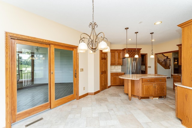 1608 Greystone Ln SW, Rochester, MN 55902 - kitchen with freestanding refrigerator, light countertops, brown cabinets, a center island, and recessed lighting