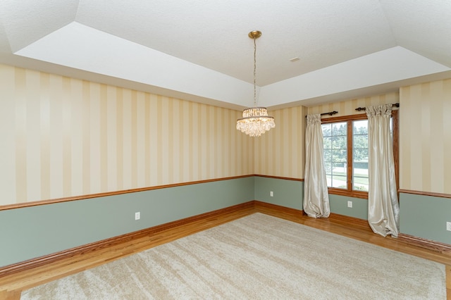 1608 Greystone Ln SW, Rochester, MN 55902 - spare room featuring wood finished floors, a chandelier, and vaulted ceiling