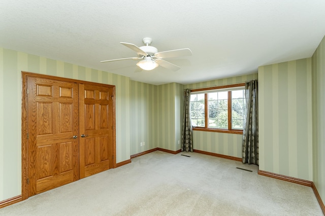 1608 Greystone Ln SW, Rochester, MN 55902 - unfurnished bedroom with carpet, wallpapered walls, and a ceiling fan
