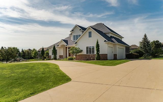 1608 Greystone Ln SW, Rochester, MN 55902 - view of front of home with driveway, brick siding, a front lawn, stucco siding, and a playground