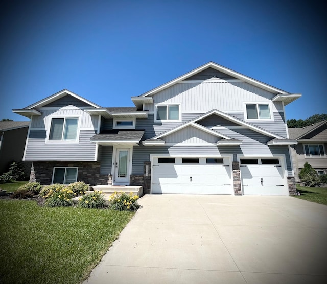 19104 Johnson St NW, Elk River, MN 55330 - view of front of property featuring concrete driveway, a garage, stone siding, and a front lawn