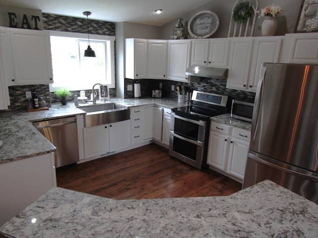 1103 15th St, Montevideo, MN 56265 - kitchen with appliances with stainless steel finishes, under cabinet range hood, tasteful backsplash, dark wood-type flooring, and white cabinets