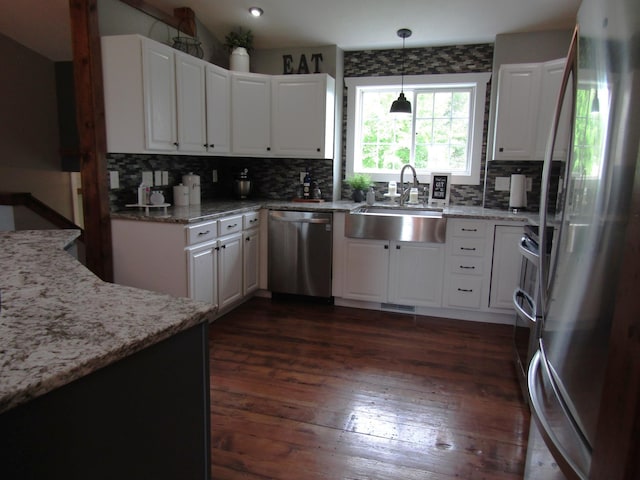 1103 15th St, Montevideo, MN 56265 - kitchen with stainless steel appliances, decorative backsplash, light stone countertops, dark wood finished floors, and white cabinets