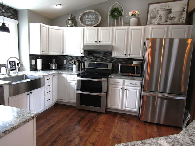 1103 15th St, Montevideo, MN 56265 - kitchen featuring appliances with stainless steel finishes, under cabinet range hood, backsplash, and white cabinetry