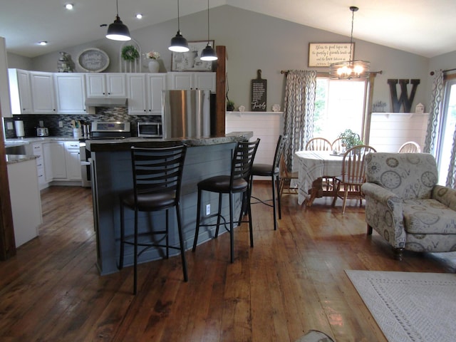 1103 15th St, Montevideo, MN 56265 - kitchen with appliances with stainless steel finishes, lofted ceiling, under cabinet range hood, white cabinets, and dark wood finished floors