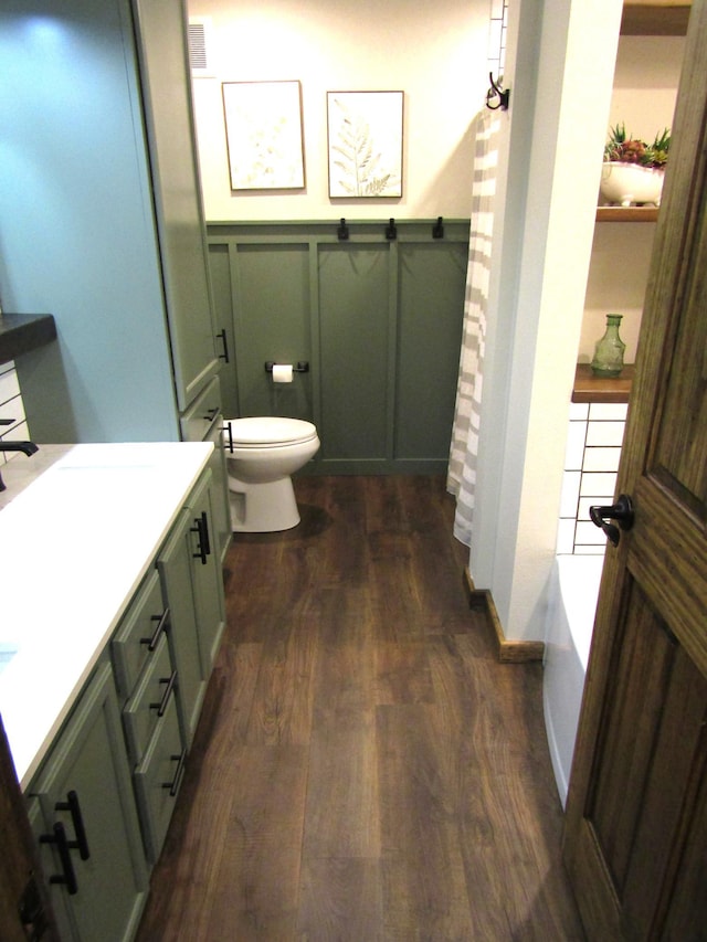 1103 15th St, Montevideo, MN 56265 - bathroom with wood finished floors, a wainscoted wall, vanity, a bathtub, and a shower with curtain
