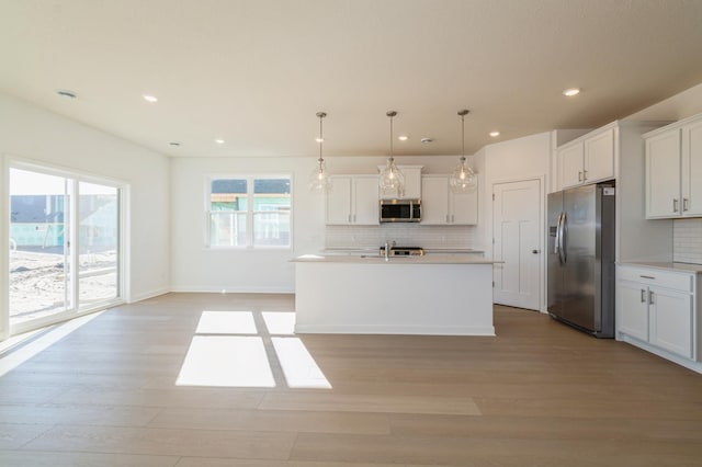 15149 Quince St NW, Andover, MN 55304 - kitchen featuring appliances with stainless steel finishes, light wood-style flooring, backsplash, white cabinetry, and recessed lighting
