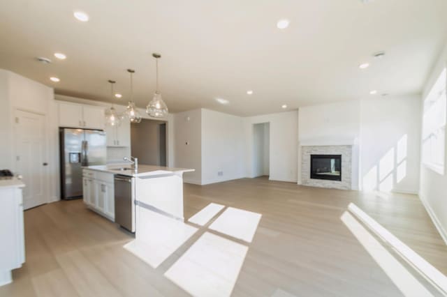 15149 Quince St NW, Andover, MN 55304 - kitchen with appliances with stainless steel finishes, white cabinets, a kitchen island with sink, light wood finished floors, and recessed lighting