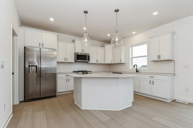4021 Heath Ln N, Oakdale, MN 55128 - kitchen with stainless steel appliances, light wood-style floors, decorative backsplash, white cabinetry, and recessed lighting