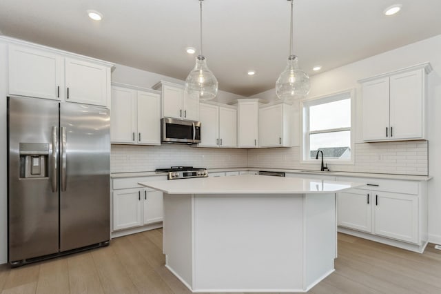 4021 Heath Ln N, Oakdale, MN 55128 - kitchen featuring stainless steel appliances, a center island, white cabinetry, light wood-style flooring, and recessed lighting