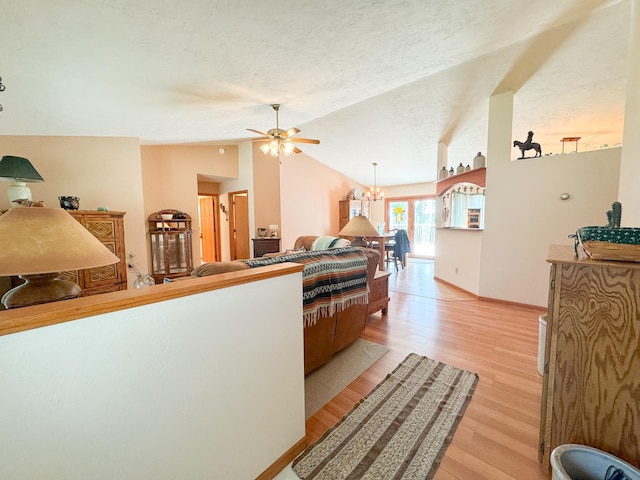 915 Stanton Ave, Fergus Falls, MN 56537 - living area featuring a ceiling fan, vaulted ceiling, light wood-type flooring, a chandelier, and a textured ceiling