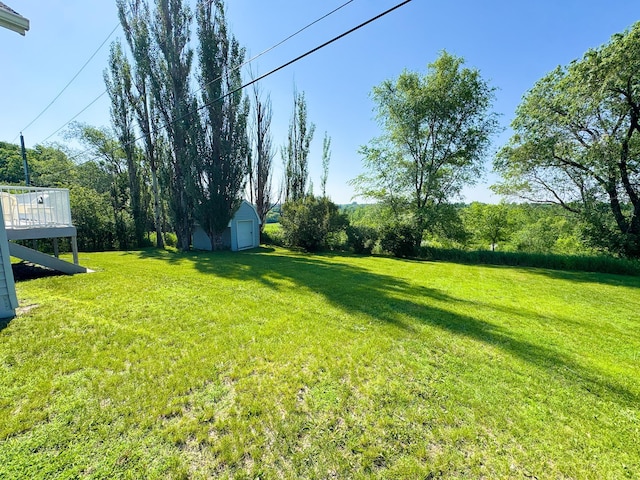 915 Stanton Ave, Fergus Falls, MN 56537 - view of grassy yard with a detached garage, an outdoor structure, and a deck