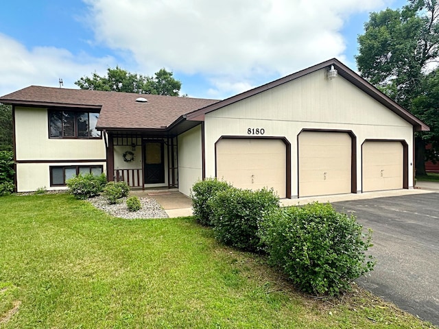 8180 Diane St, Circle Pines, MN 55014 - split level home with an attached garage, a front lawn, asphalt driveway, and roof with shingles