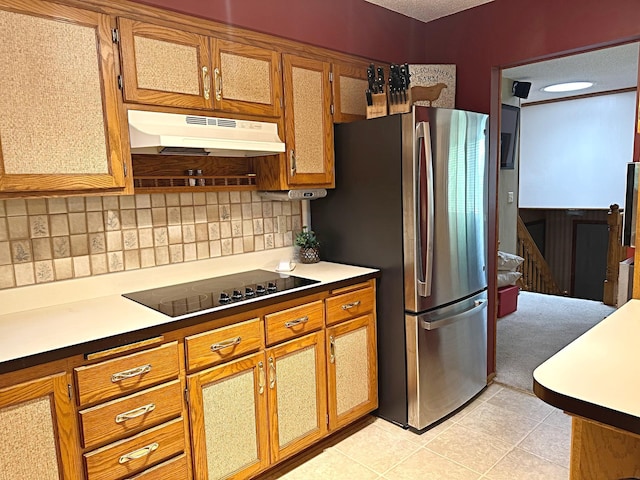 8180 Diane St, Circle Pines, MN 55014 - kitchen with black electric stovetop, under cabinet range hood, freestanding refrigerator, brown cabinets, and a textured ceiling