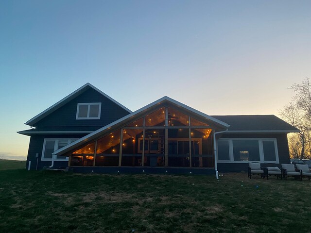 24718 Elbow Rd, Pelican Rapids, MN 56572 - back of house at dusk featuring a sunroom and a lawn