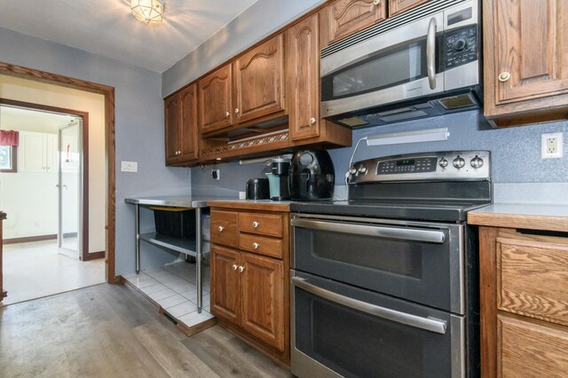 W224S9735 Big Bend Dr, Vernon, WI 53103 - kitchen with stainless steel appliances, wood finished floors, brown cabinetry, and light countertops
