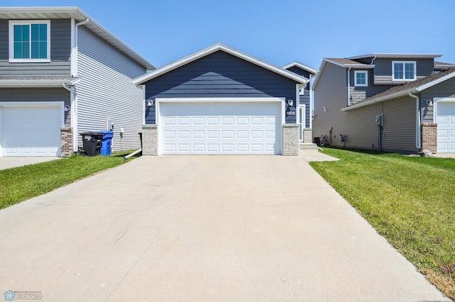 6870 17th St S, Fargo, ND 58104 - view of front facade featuring a front lawn, brick siding, and a garage