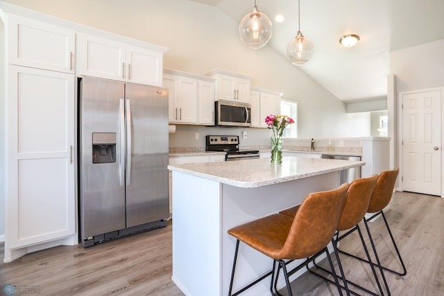 6870 17th St S, Fargo, ND 58104 - kitchen featuring appliances with stainless steel finishes, a center island, white cabinets, a breakfast bar, and light wood finished floors