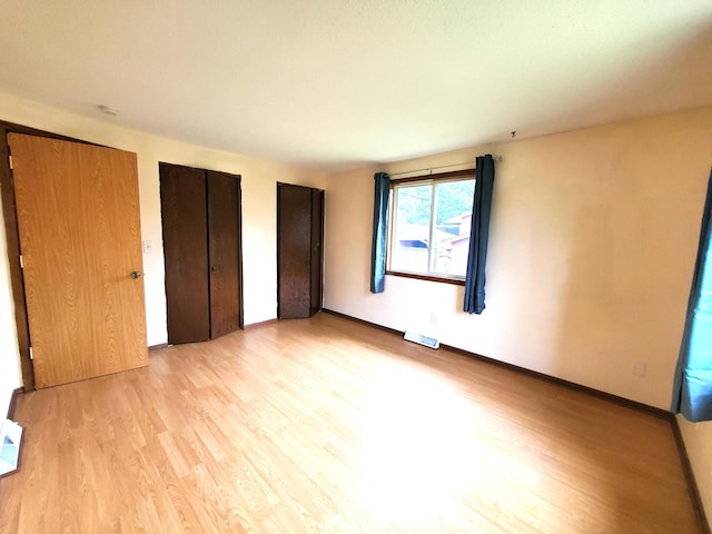 8921 49th Ave N, New Hope, MN 55428 - unfurnished bedroom featuring light wood-style flooring and two closets