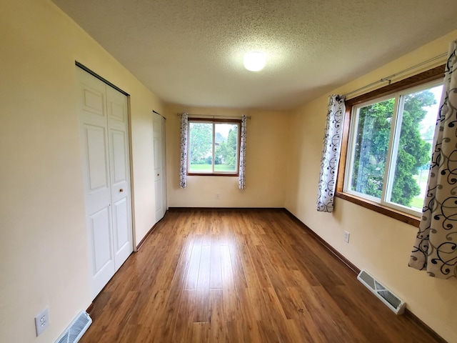 8921 49th Ave N, New Hope, MN 55428 - unfurnished bedroom featuring wood finished floors and a textured ceiling