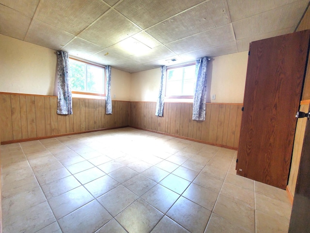 8921 49th Ave N, New Hope, MN 55428 - spare room with wainscoting, plenty of natural light, wooden walls, and tile patterned flooring
