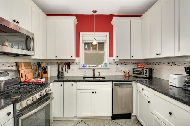 1914 Grand Ave, Saint Paul, MN 55105 - kitchen featuring appliances with stainless steel finishes, white cabinets, backsplash, decorative light fixtures, and dark stone countertops