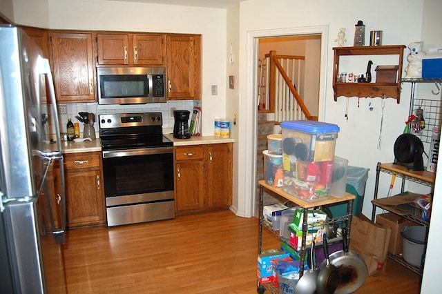1445 Ottawa Ave S, Golden Valley, MN 55416 - kitchen featuring stainless steel appliances, light countertops, brown cabinets, and light wood finished floors