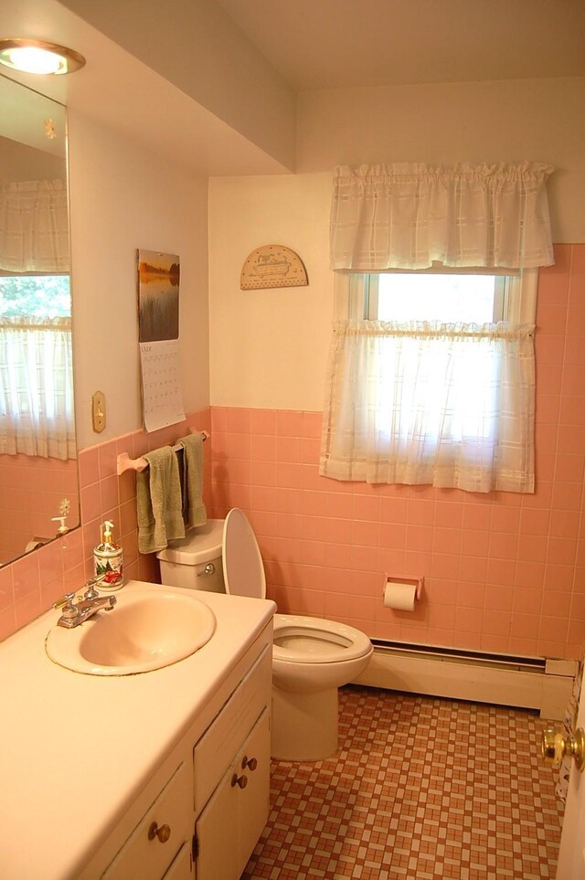 1445 Ottawa Ave S, Golden Valley, MN 55416 - bathroom featuring tile walls, plenty of natural light, a baseboard radiator, vanity, and wainscoting